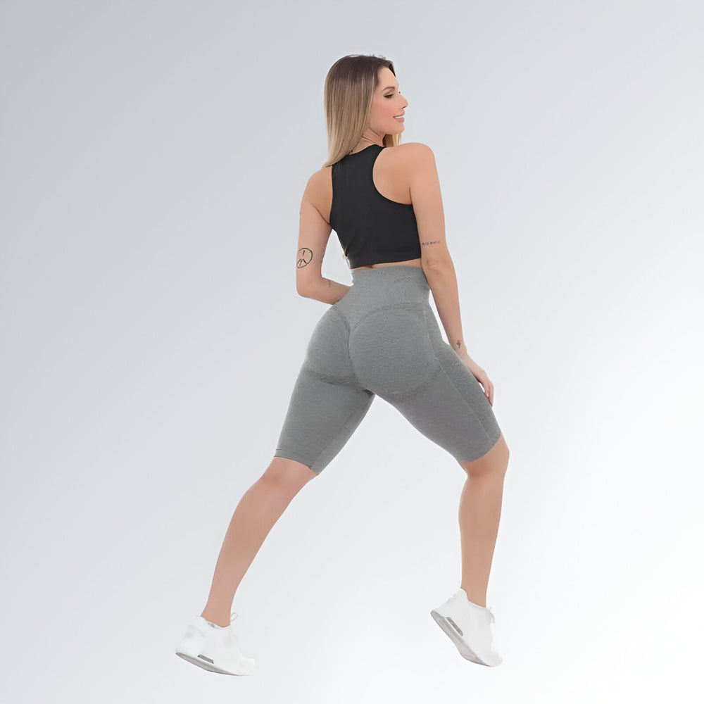 Bermuda fitness feminina cinza claro de cintura alta, modelo empina bumbum com compressão e tecido elástico.