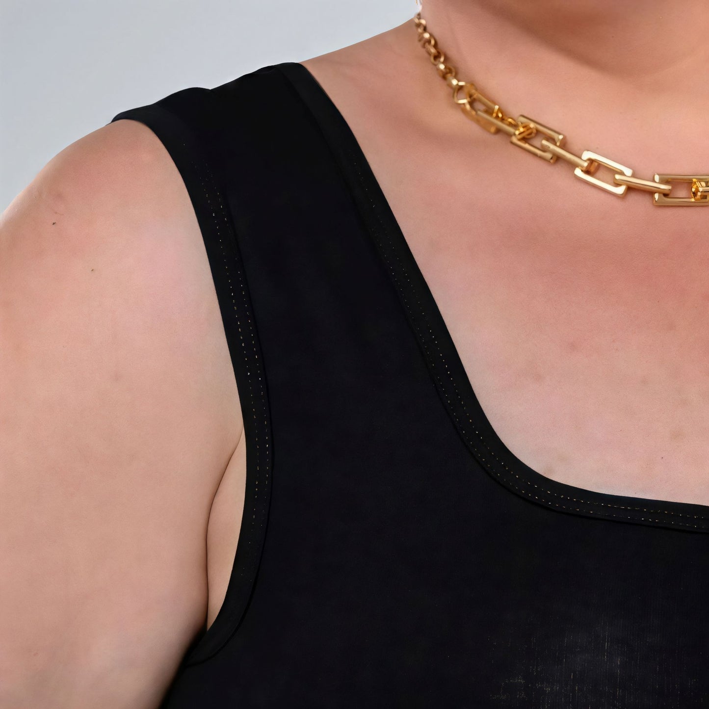 Blusa regata preta feminina plus size com decote quadrado, alça larga e tecido confortável.