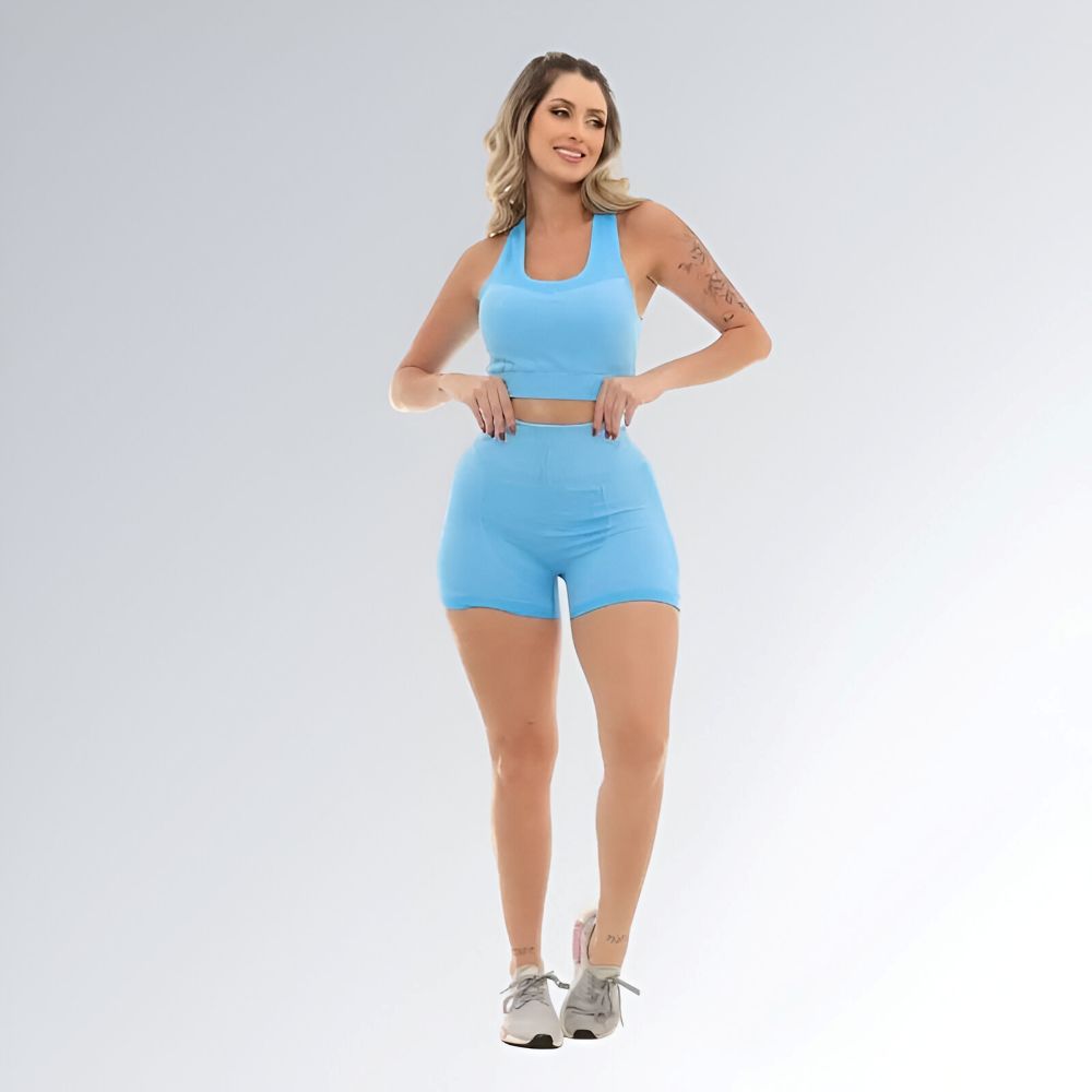 Conjunto fitness feminino azul claro, composto por top cropped sem mangas e shorts cintura alta em tecido elástico.