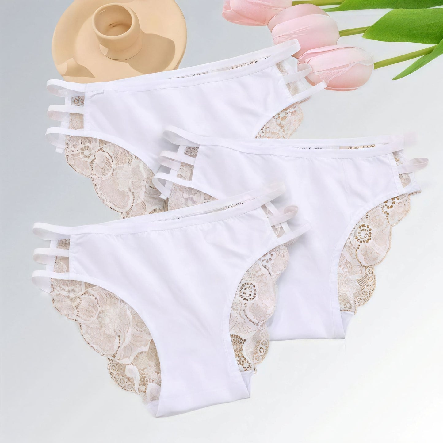 Conjunto com 3 calcinhas femininas brancas de renda floral, cintura baixa e tiras laterais finas.