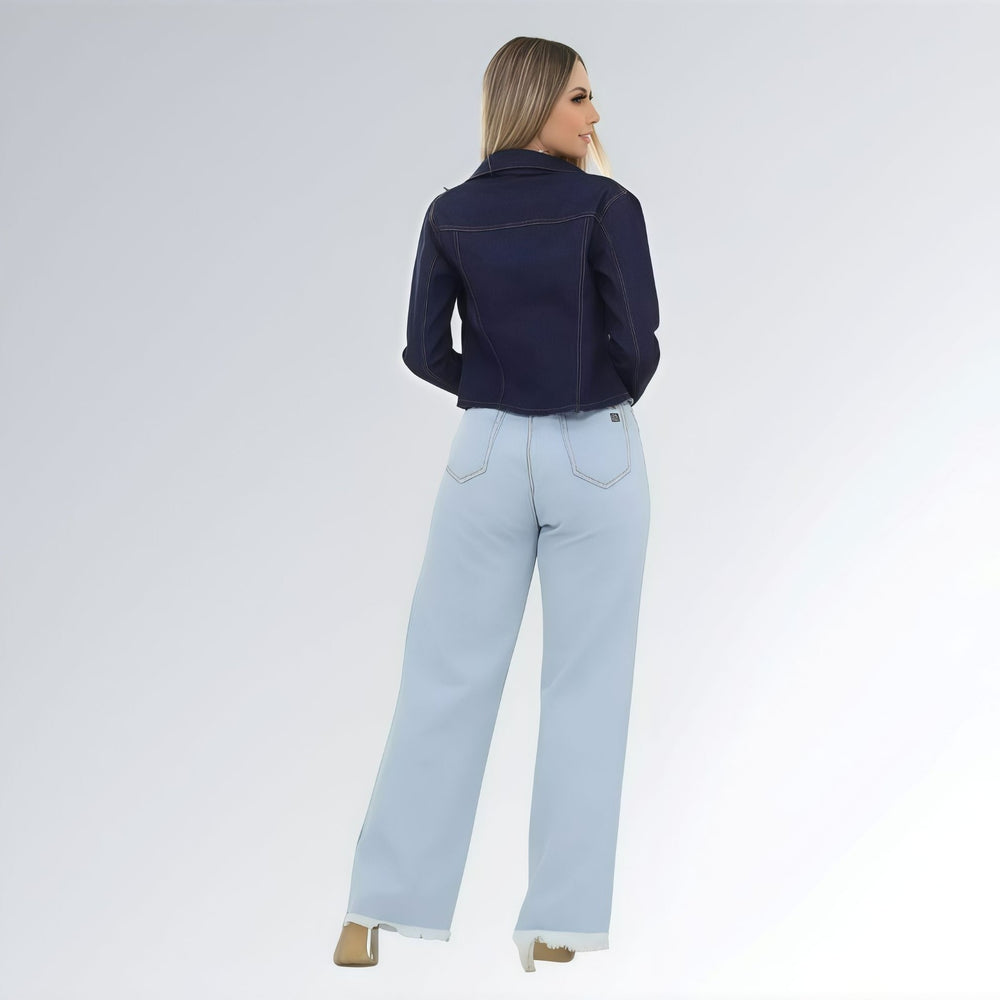 Jaqueta jeans cropped feminina azul escuro com puídos, bolsos frontais com aba e fechamento por botões.