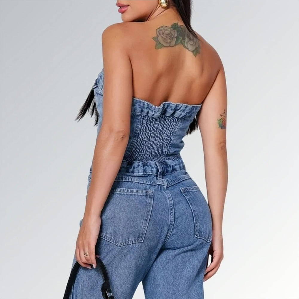 Macacão jeans feminino longo sem mangas com fechamento frontal por botões, cintura ajustada e pernas largas, peça moderna disponível para venda online de moda casual e elegante.