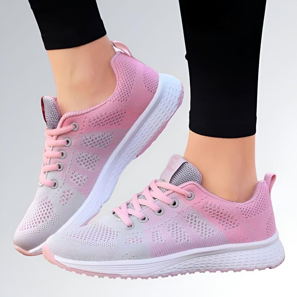 Tênis esportivo feminino com cabedal em malha respirável, degradê branco e rosa, solado branco texturizado.