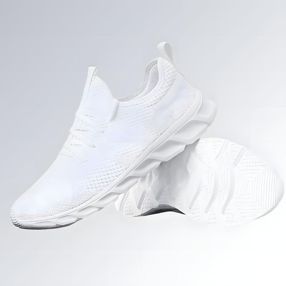 Tênis esportivo unissex branco com cabedal em malha respirável, solado anatômico ondulado e design moderno.