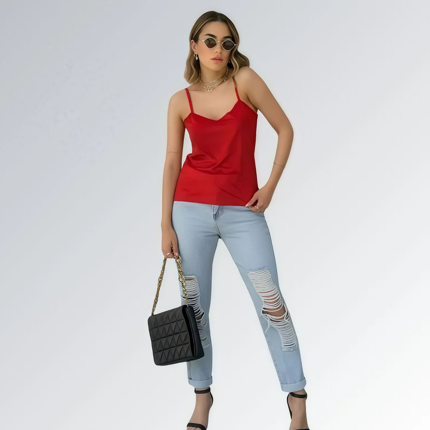 Blusa regata veludo estilo sueco feminina vermelha com alças finas, combinada com calça jeans azul clara e acessórios minimalistas — peça moderna disponível para venda online de moda casual.