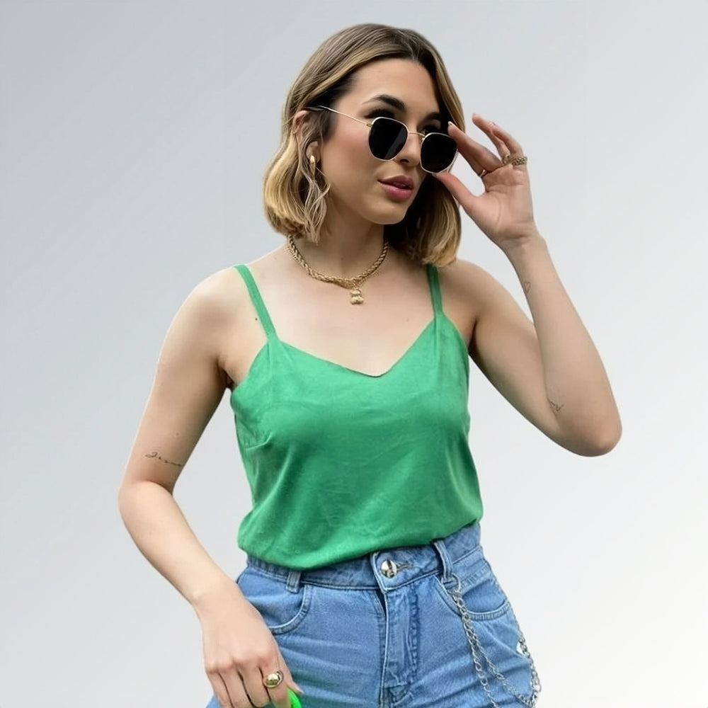 Blusa regata veludo estilo sueco feminina verde com alças finas, combinada com calça jeans azul clara e acessórios minimalistas — peça moderna disponível para venda online de moda casual.