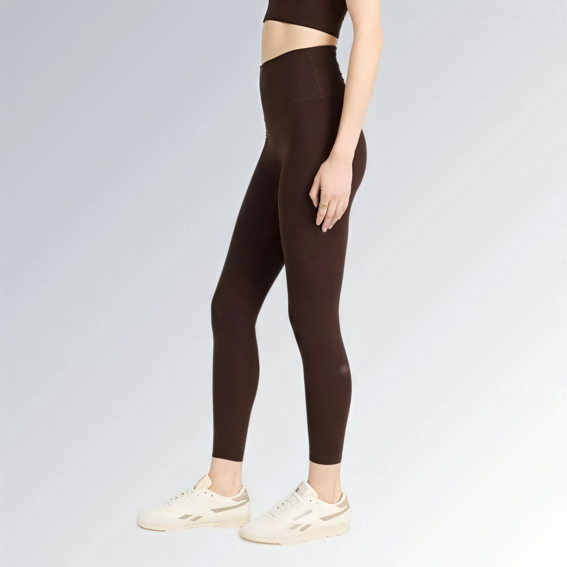 Calça legging feminina marrom escura de cintura alta com ajuste firme, estilo urbano esportivo e visual moderno.