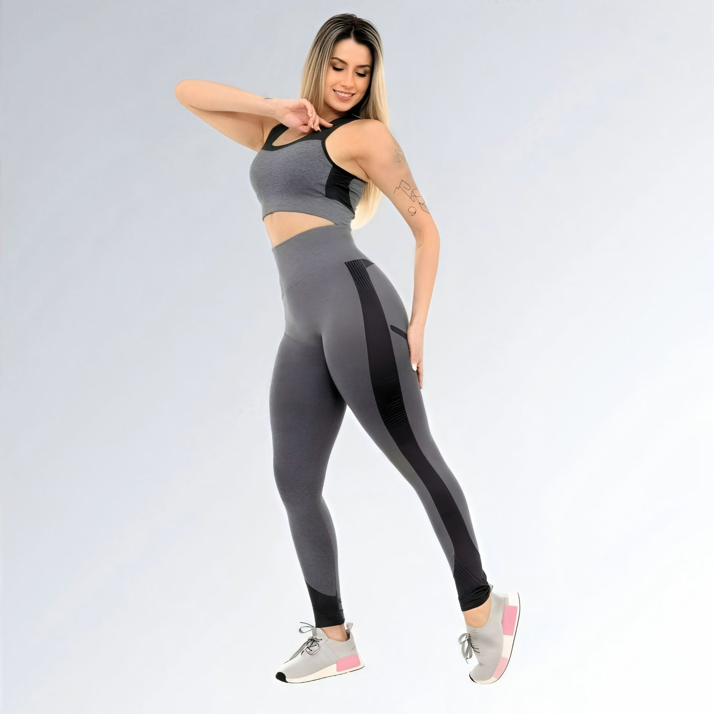 Calça legging feminina para academia, cinza escura com detalhes pretos, cintura alta e tecido elástico de compressão.