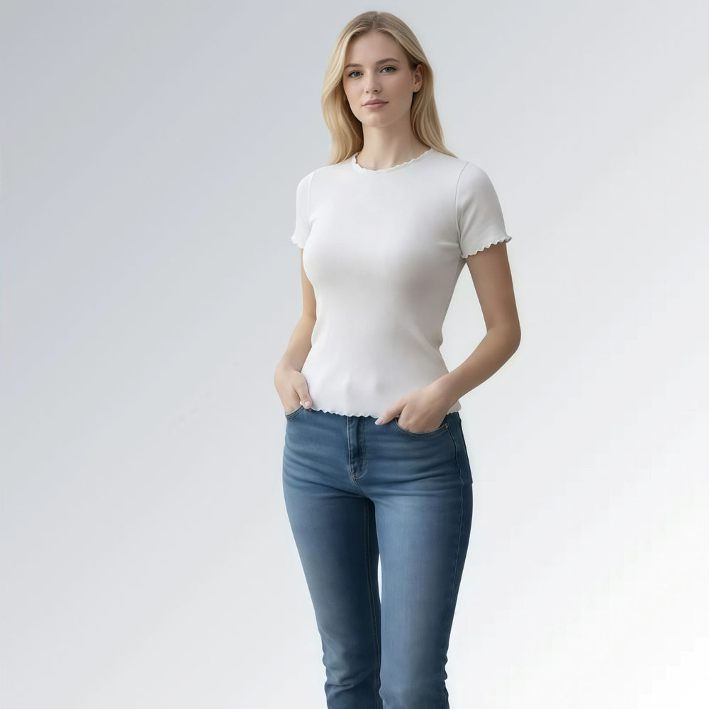 Camiseta feminina estilo vintage gola careca com acabamento ondulado em tecido canelado branco, combinada com jeans azul — peça moderna disponível para venda online de moda casual.