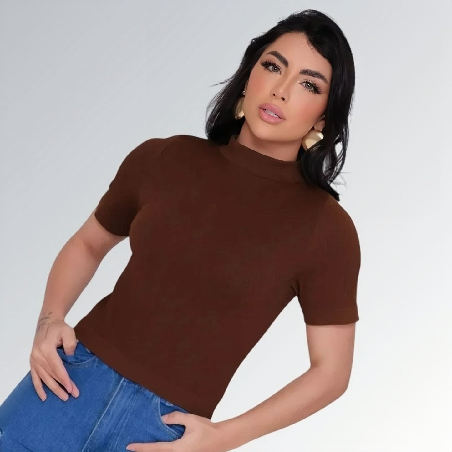 Camiseta manga curta gola alta parcial feminina marrom ajustada, combinada com calça jeans cargo azul com bolsos laterais — peça moderna disponível para venda online de moda casual.