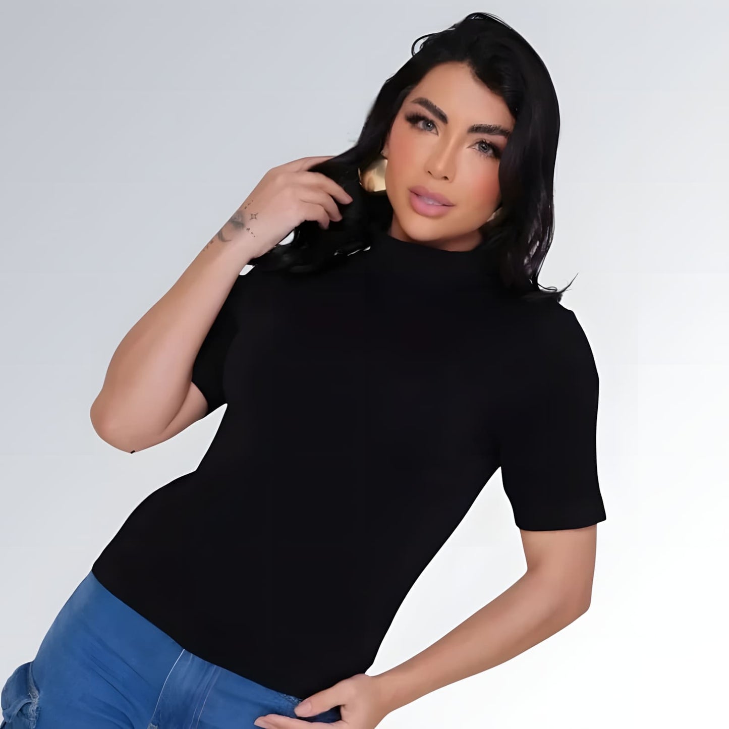 Camiseta manga curta gola alta parcial feminina preta ajustada, combinada com calça jeans cargo azul com bolsos laterais — peça moderna disponível para venda online de moda casual.