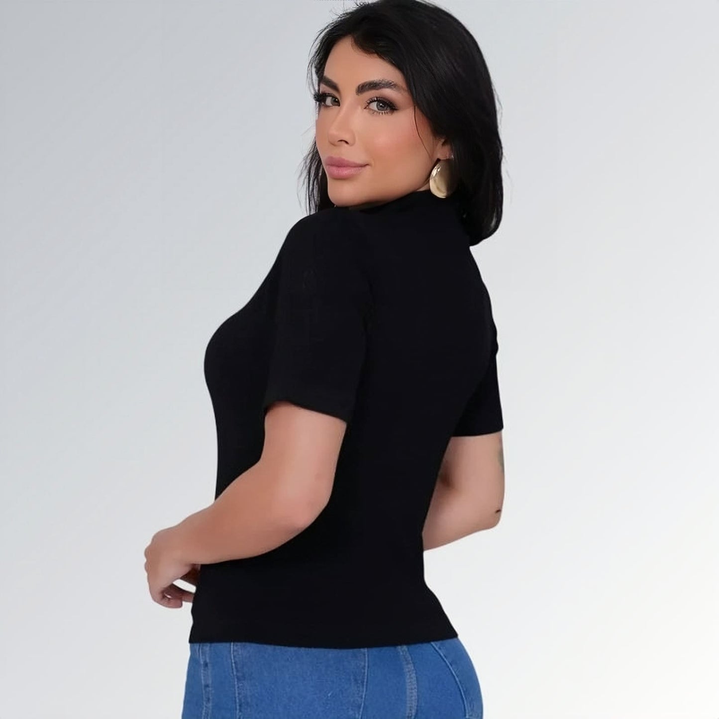 Camiseta manga curta gola alta parcial feminina preta ajustada, combinada com calça jeans cargo azul com bolsos laterais — peça moderna disponível para venda online de moda casual.
