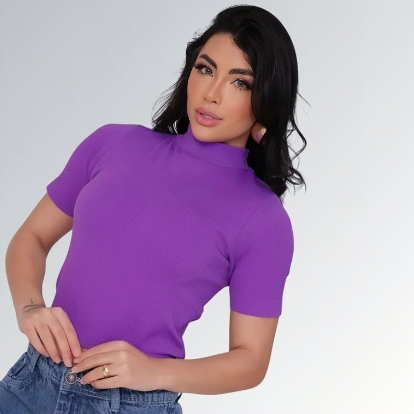 Camiseta manga curta gola alta parcial feminina roxa ajustada, combinada com calça jeans cargo azul com bolsos laterais — peça moderna disponível para venda online de moda casual.