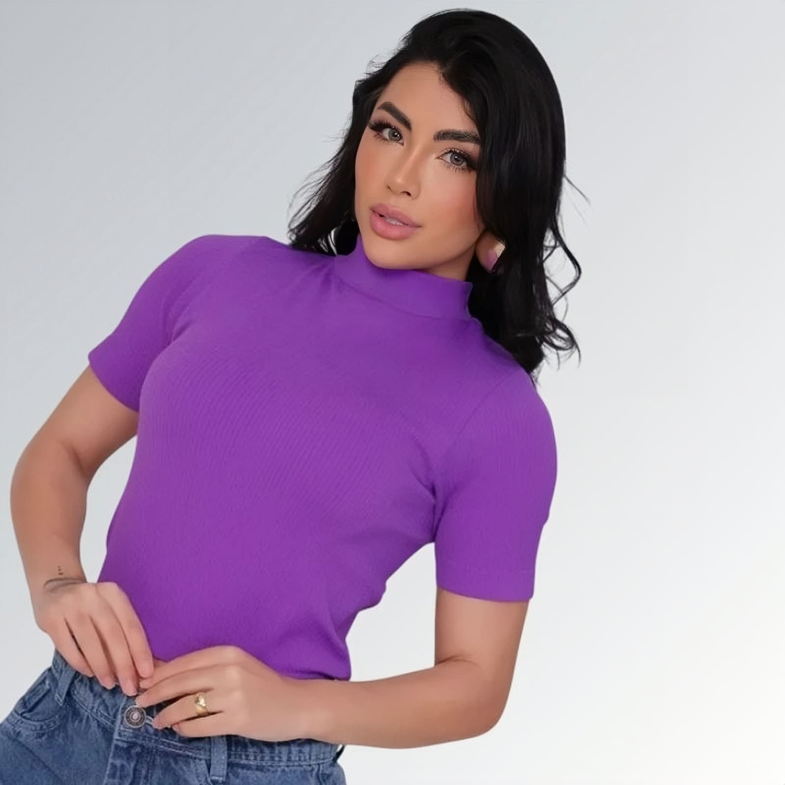 Camiseta manga curta gola alta parcial feminina roxa ajustada, combinada com calça jeans cargo azul com bolsos laterais — peça moderna disponível para venda online de moda casual.