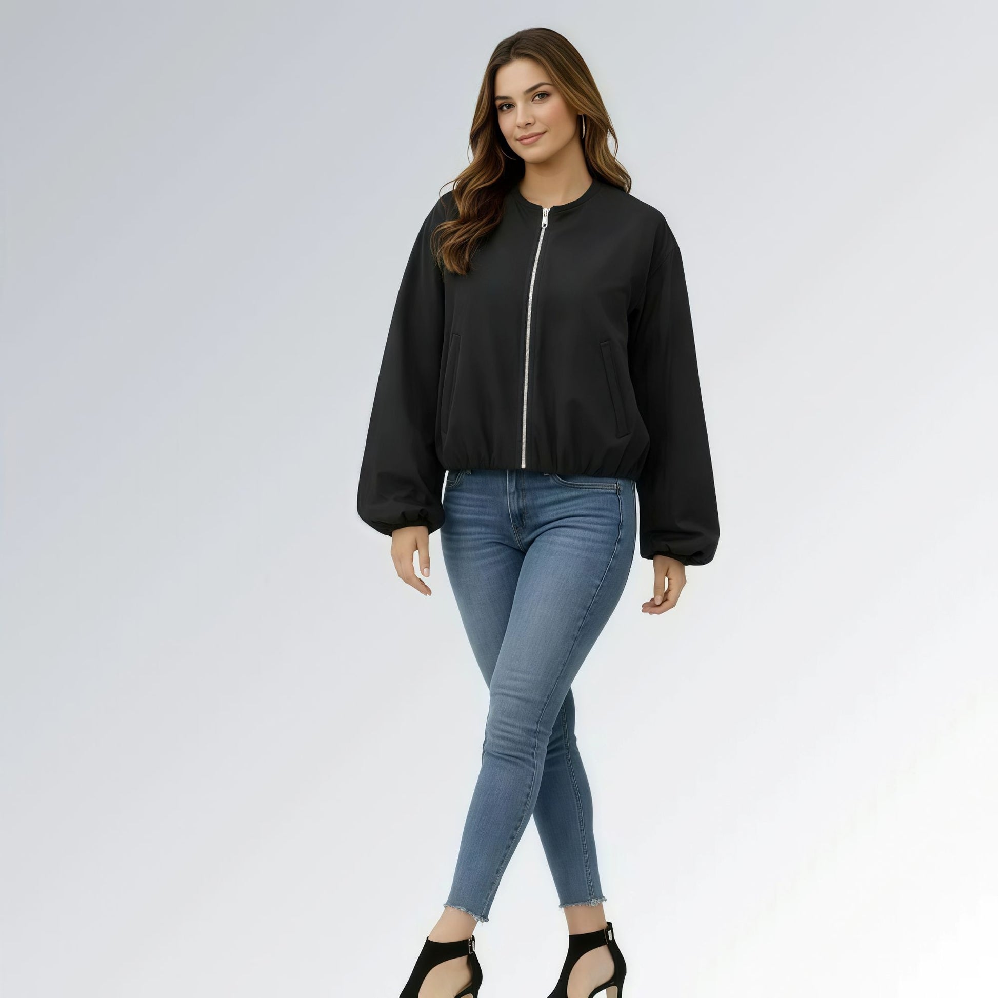 Mulher usando jaqueta feminina preta cropped com zíper metálico, mangas bufantes e calça jeans skinny, estilo casual moderno para o outono.