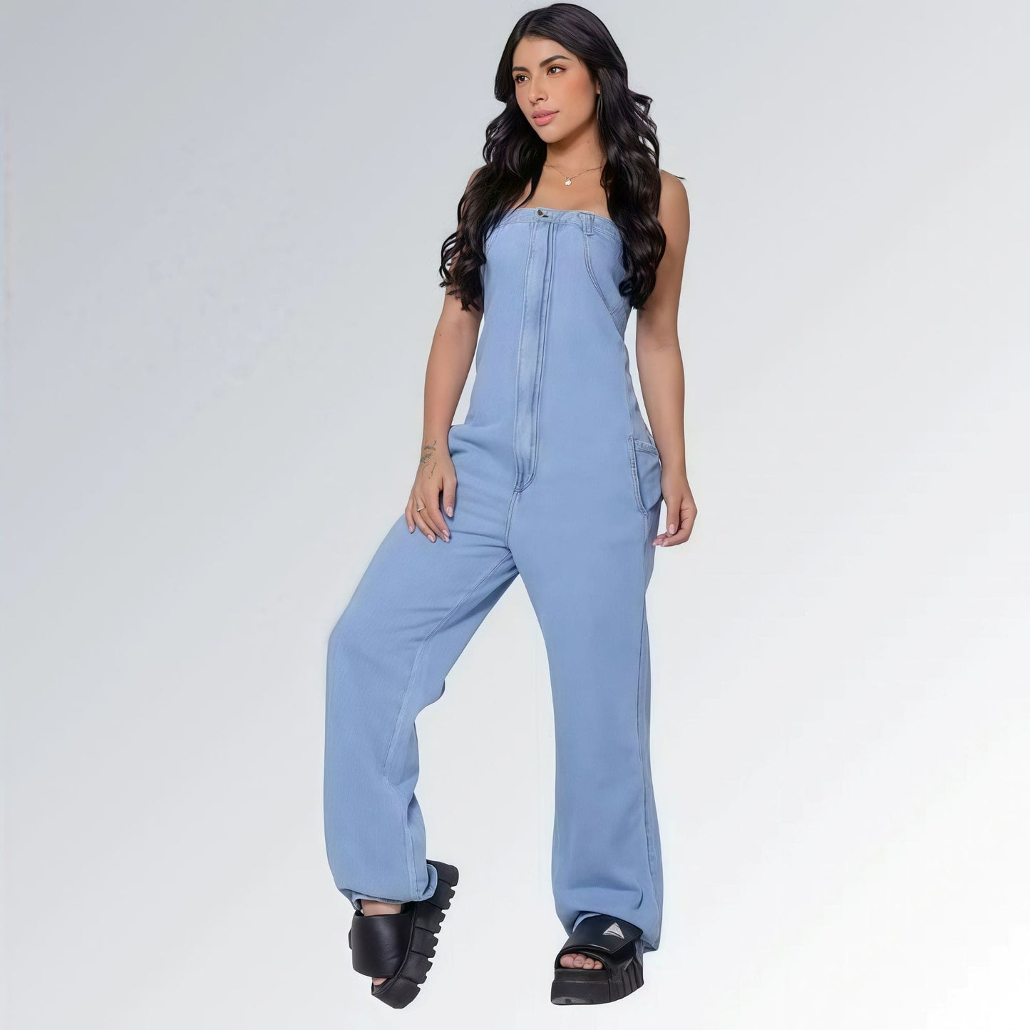 Macacão azul jeans claro longo feminino tomara que caia e bolsos laterais, pernas largas e sandálias plataforma pretas — peça moderna disponível para venda online de moda casual.