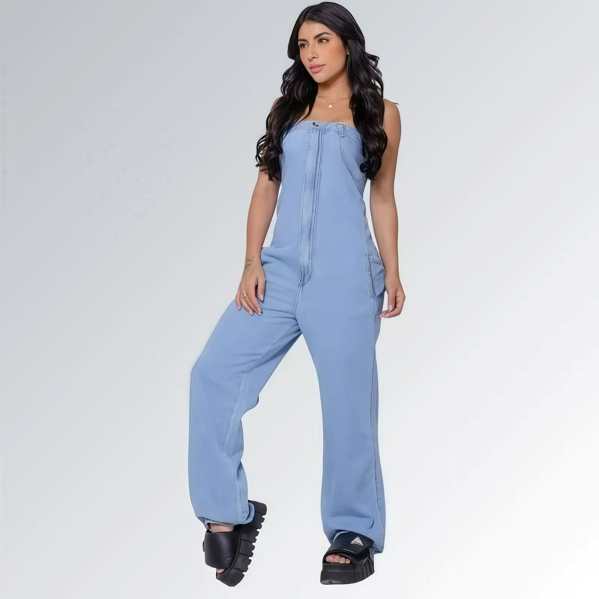 Macacão azul jeans claro longo feminino tomara que caia e bolsos laterais, pernas largas e sandálias plataforma pretas — peça moderna disponível para venda online de moda casual.