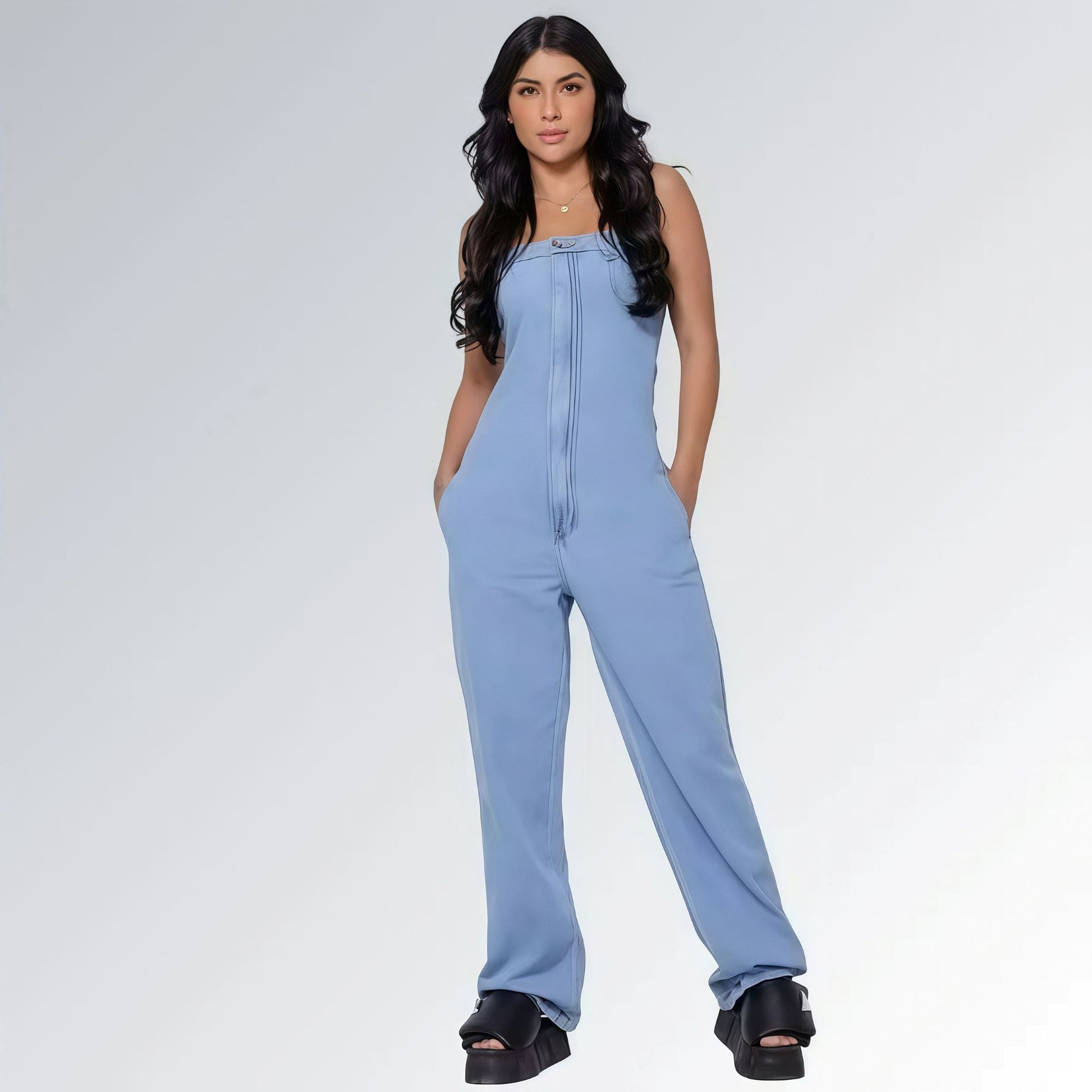 Macacão azul jeans claro longo feminino tomara que caia e bolsos laterais, pernas largas e sandálias plataforma pretas — peça moderna disponível para venda online de moda casual.