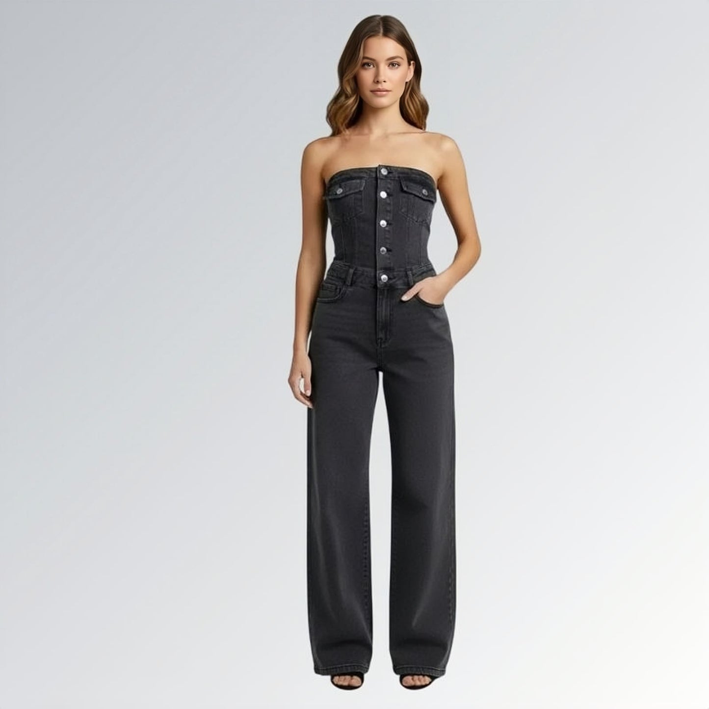 Macacão preto jeans feminino longo sem mangas com fechamento frontal por botões, cintura ajustada e pernas largas,  peça moderna disponível para venda online de moda casual e elegante.