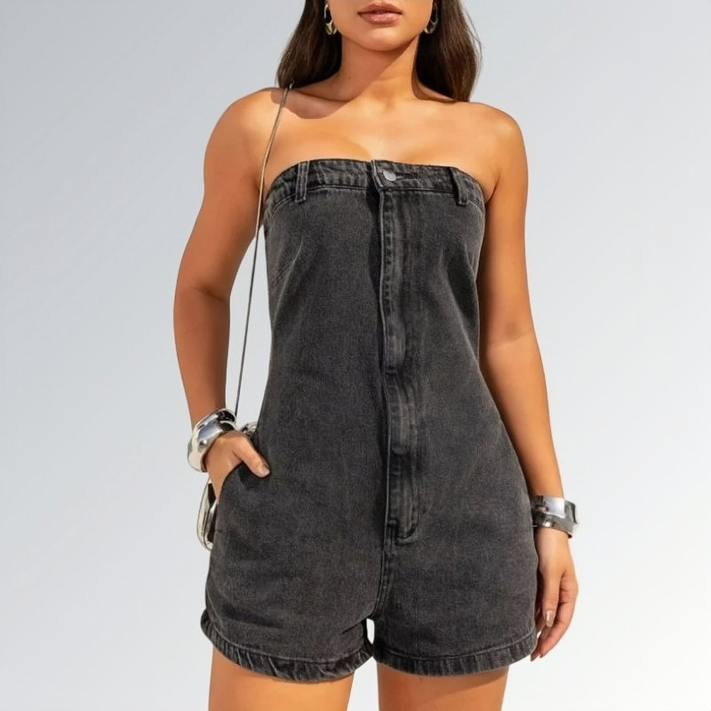 Macaquinho jeans feminino tomara que caia preto com bolsos laterais e detalhe de costura frontal, peça moderna disponível para venda online de moda casual.