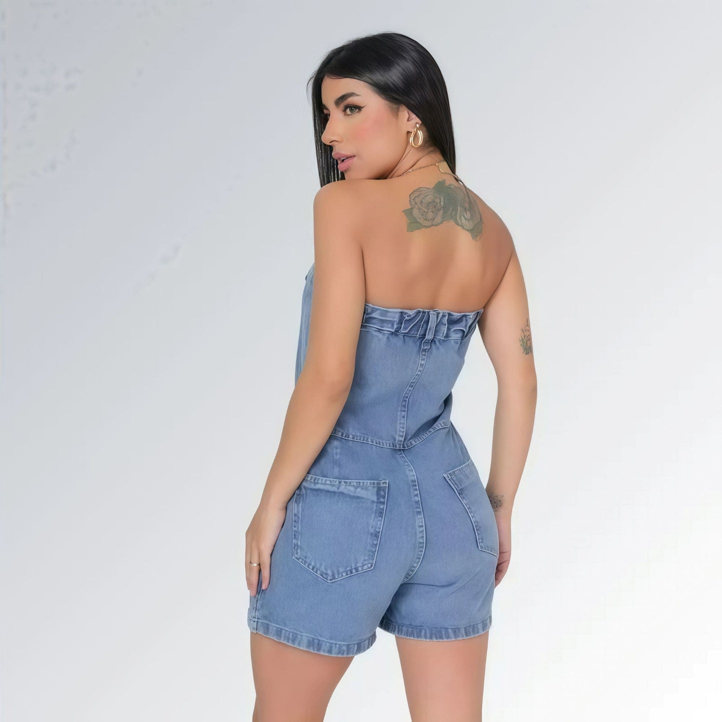 Macaquinho jeans feminino tomara que caia azul claro com bolsos laterais e detalhe de costura frontal, peça moderna disponível para venda online de moda casual.