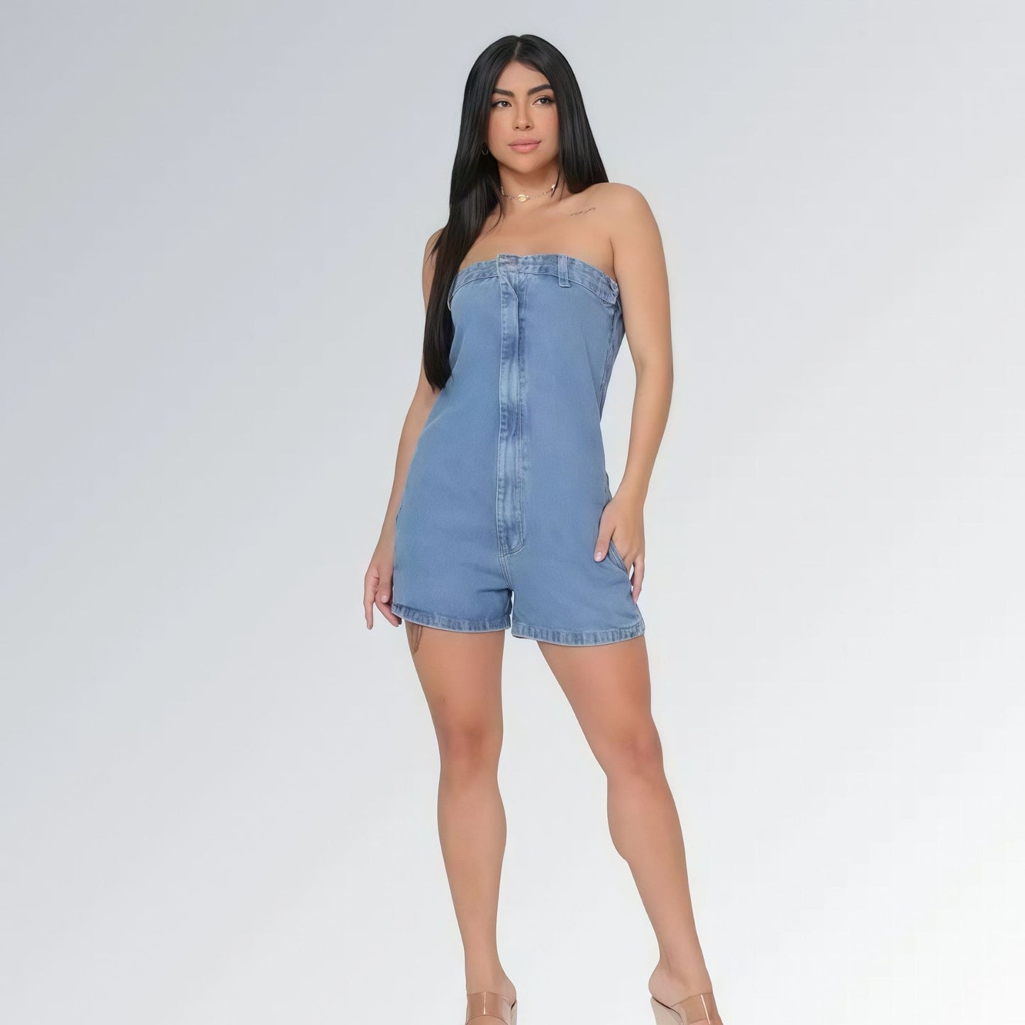Macaquinho jeans feminino tomara que caia azul claro com bolsos laterais e detalhe de costura frontal, peça moderna disponível para venda online de moda casual.