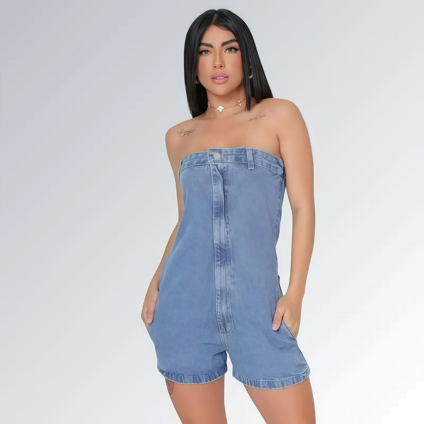 Macaquinho jeans feminino tomara que caia azul claro com bolsos laterais e detalhe de costura frontal, peça moderna disponível para venda online de moda casual.