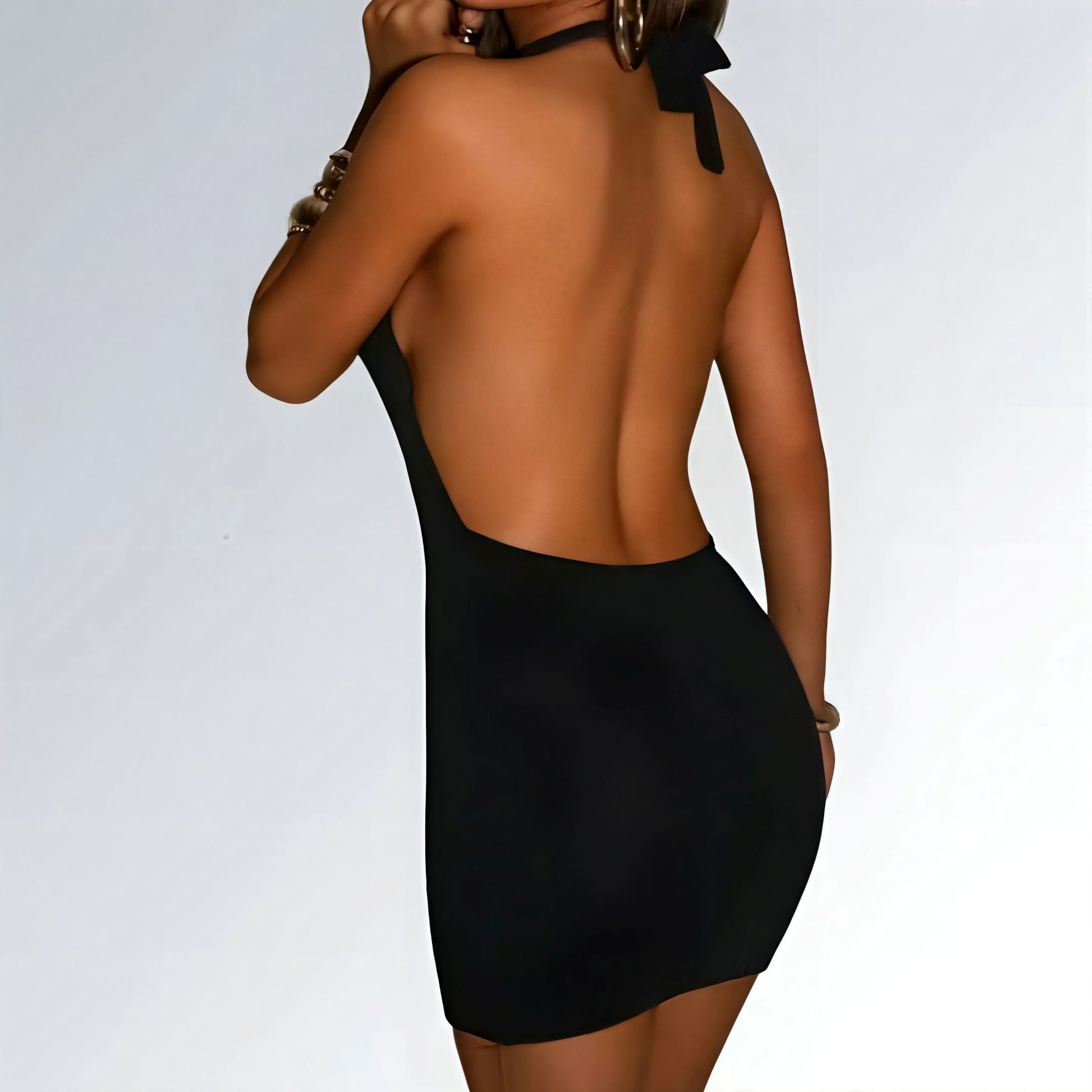 Mini vestido feminino preto estilo streetwear com decote halter, laterais abertas e modelagem justa.