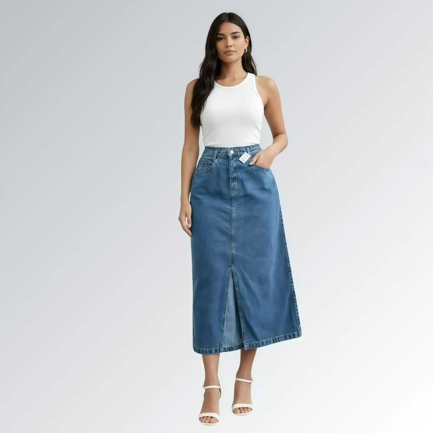 Saia jeans denim essential feminina azul com design clássico de cinco bolsos, fenda frontal e detalhe de costura central — peça versátil disponível para venda online de moda casual.