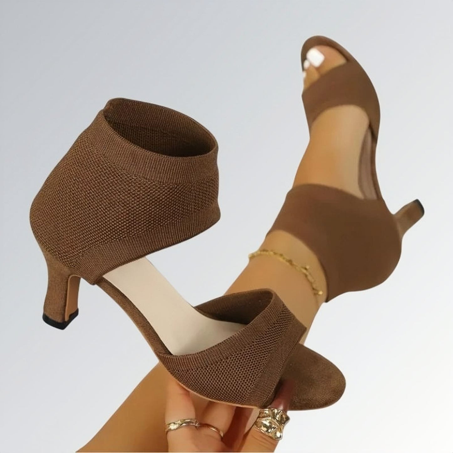 Sandália feminina salto alto fino slip on marrom com tira no calcanhar, textura em malha e design moderno de bico aberto — calçado elegante disponível para venda online.