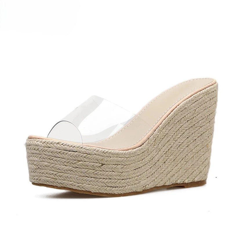 Tamanco feminino com salto anabela alto e plataforma revestida em juta, tiras transparentes em PVC e sola antiderrapante.