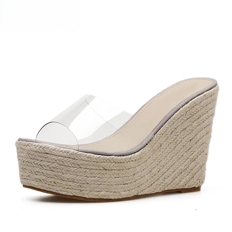 Tamanco feminino com salto anabela alto e plataforma revestida em juta, tiras transparentes em PVC e sola antiderrapante.