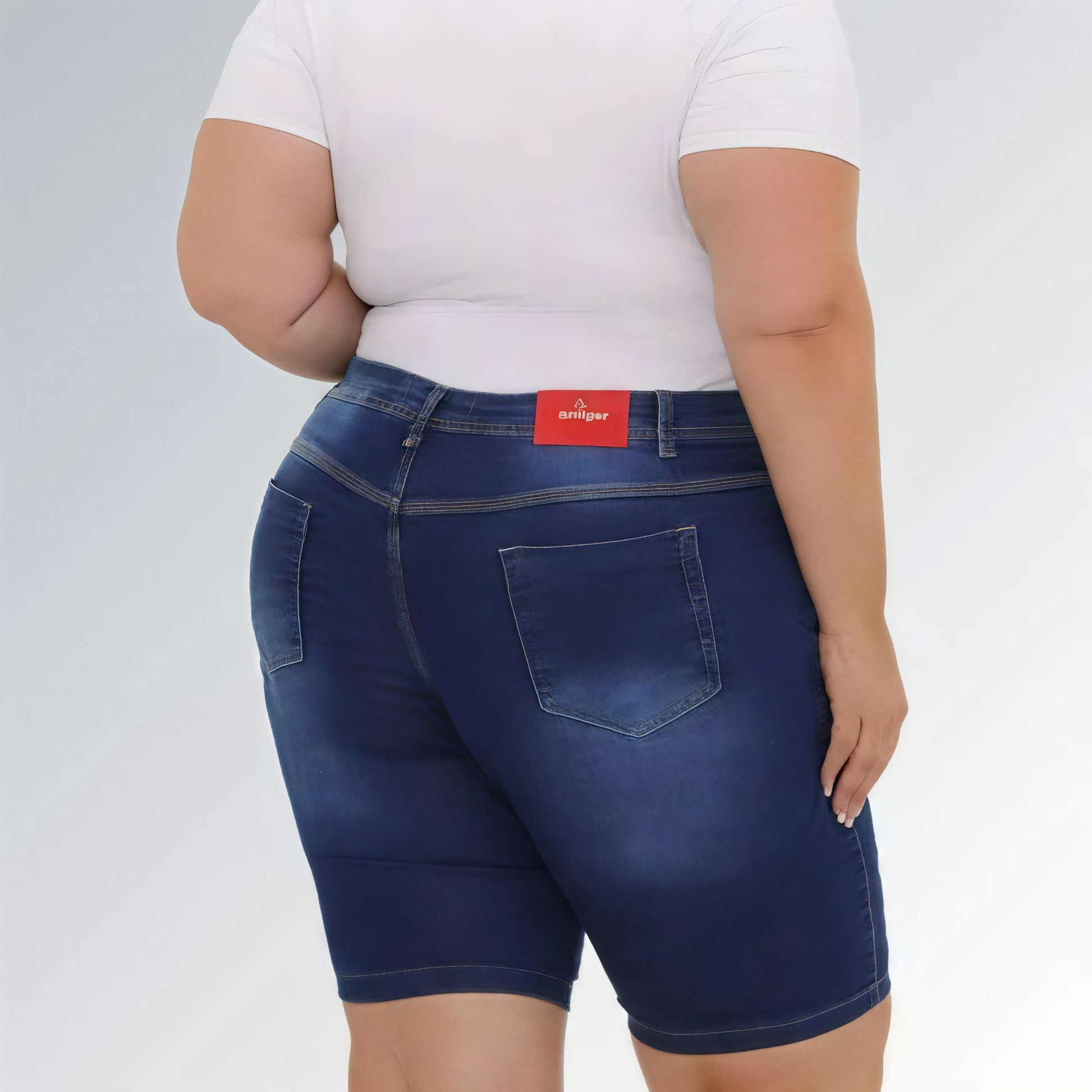 Shorts jeans feminino plus size azul escuro, cintura alta, modelo premium com bolsos e costura aparente.