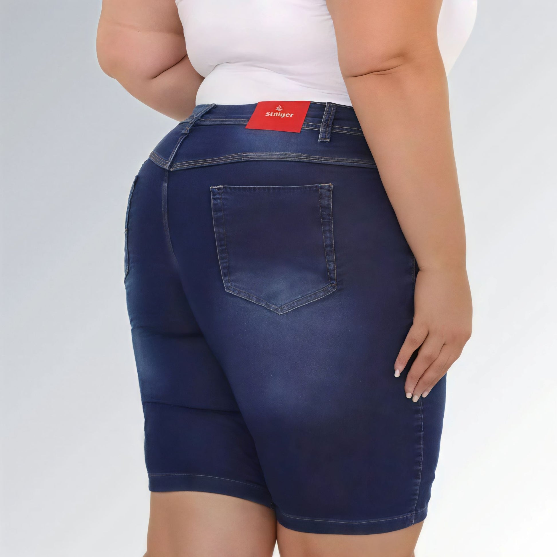 Shorts jeans feminino plus size azul escuro, cintura alta, modelo premium com bolsos e costura aparente.