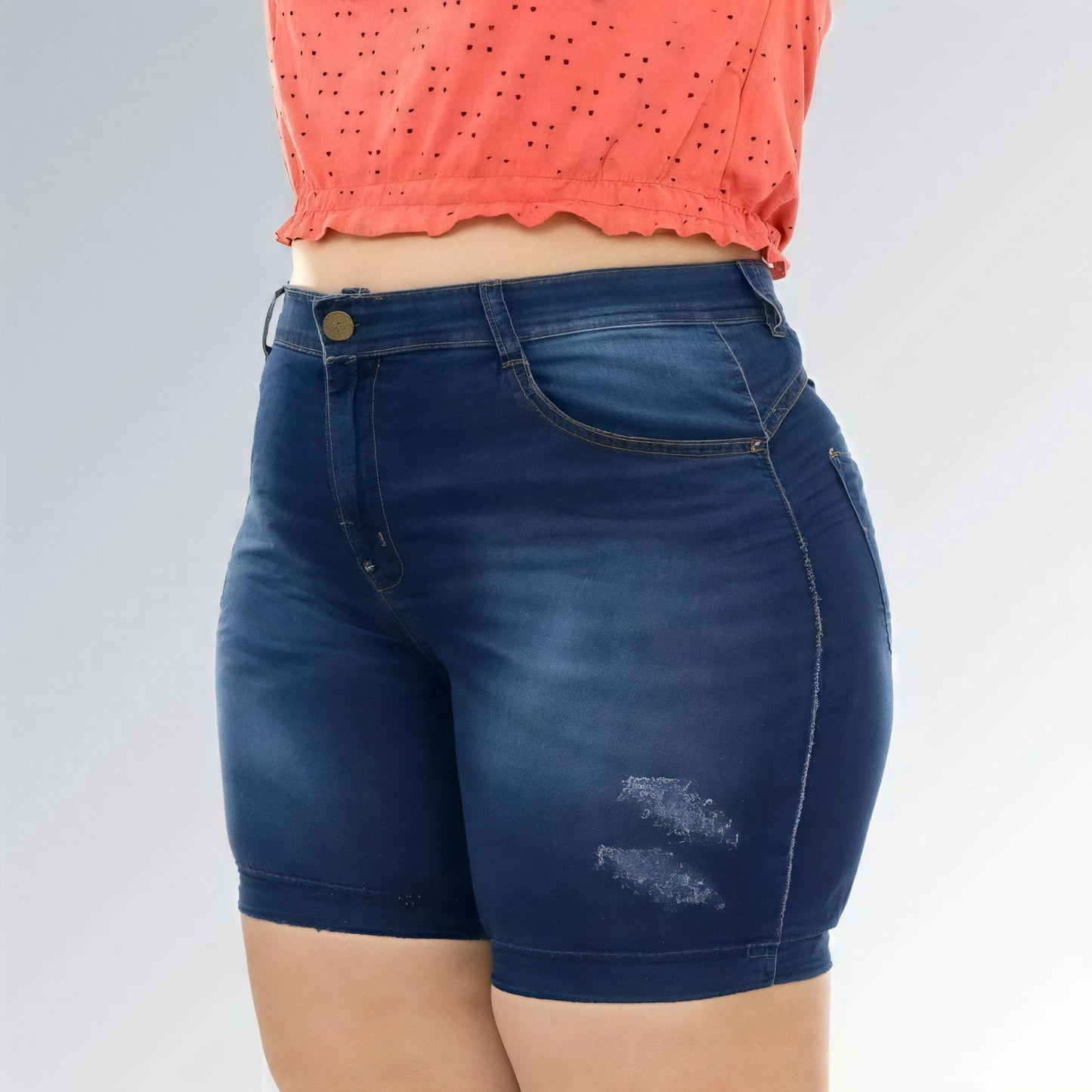 Shorts jeans feminino plus size azul escuro, cintura alta, modelo premium com bolsos e detalhe desfiado.