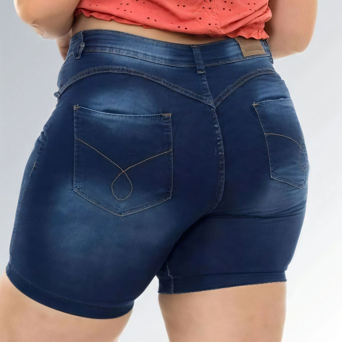 Shorts jeans feminino plus size azul escuro, cintura alta, modelo premium com bolsos e detalhe desfiado.