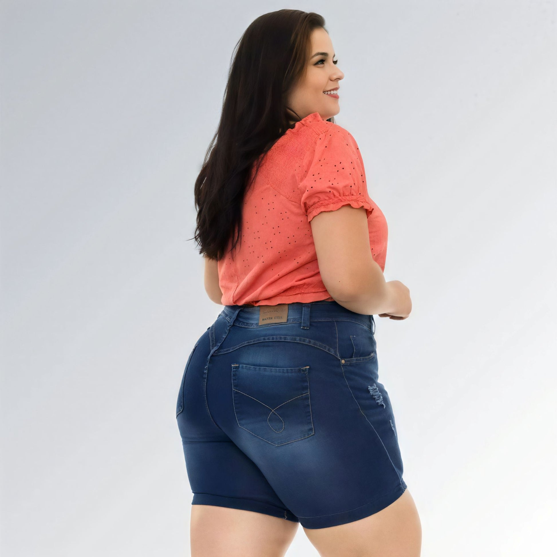 Shorts jeans feminino plus size azul escuro, cintura alta, modelo premium com bolsos e detalhe desfiado.