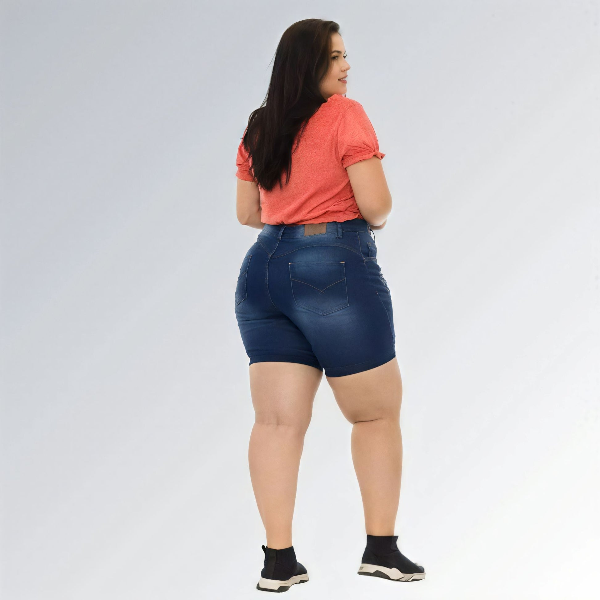 Shorts jeans feminino plus size azul escuro, cintura alta, modelo premium com bolsos e detalhe desfiado.