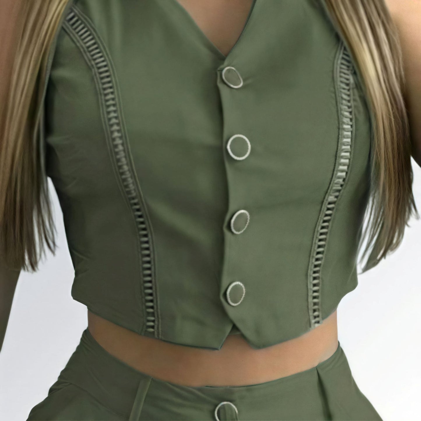 Conjunto feminino verde com top cropped sem mangas, decote V com botões prateados e short de cintura alta com detalhe metálico.