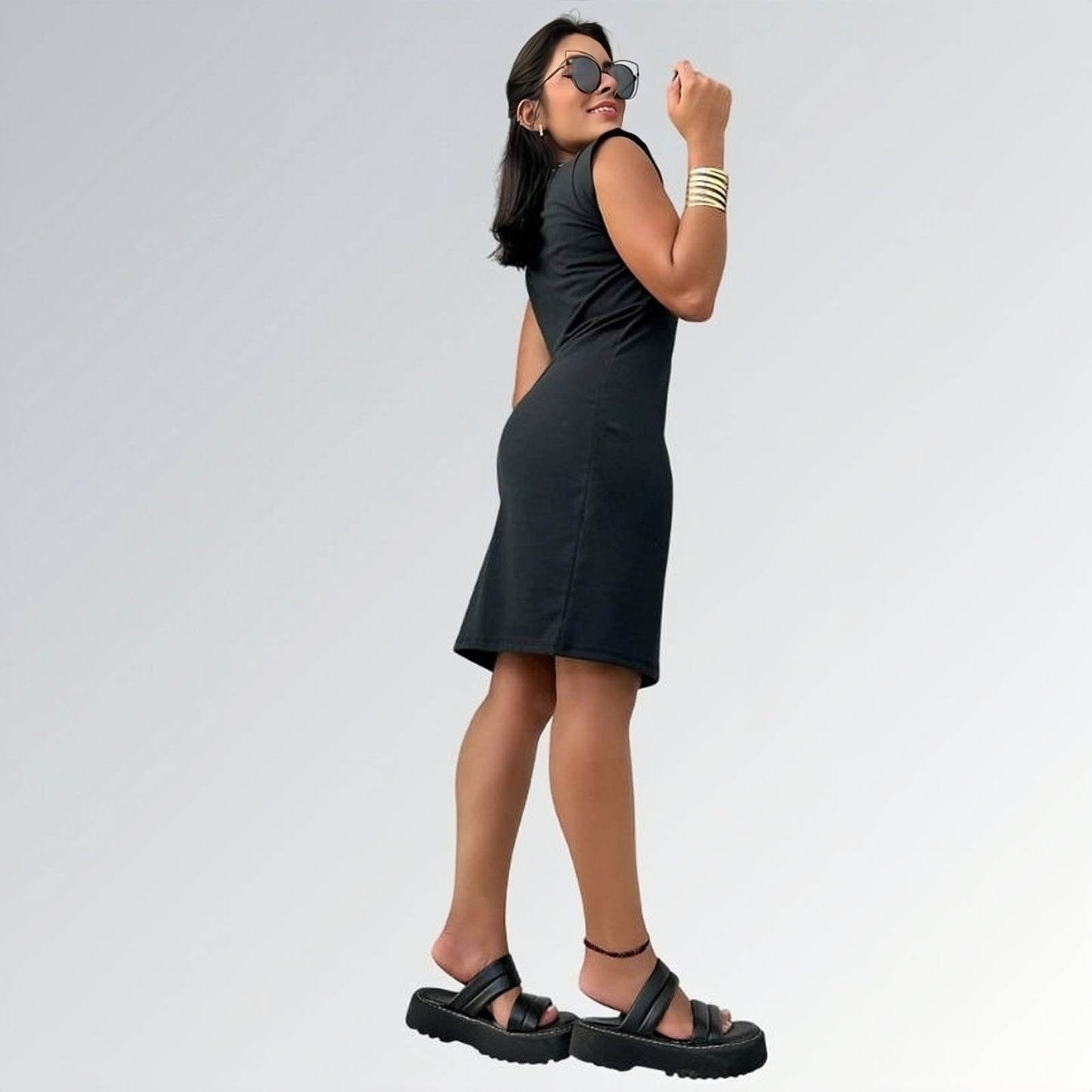 Vestido preto feminino curto de manga curta até o joelho com tecido liso, acessórios dourados e sandálias plataforma pretas — peça minimalista disponível para venda online de moda casual e semi-formal.