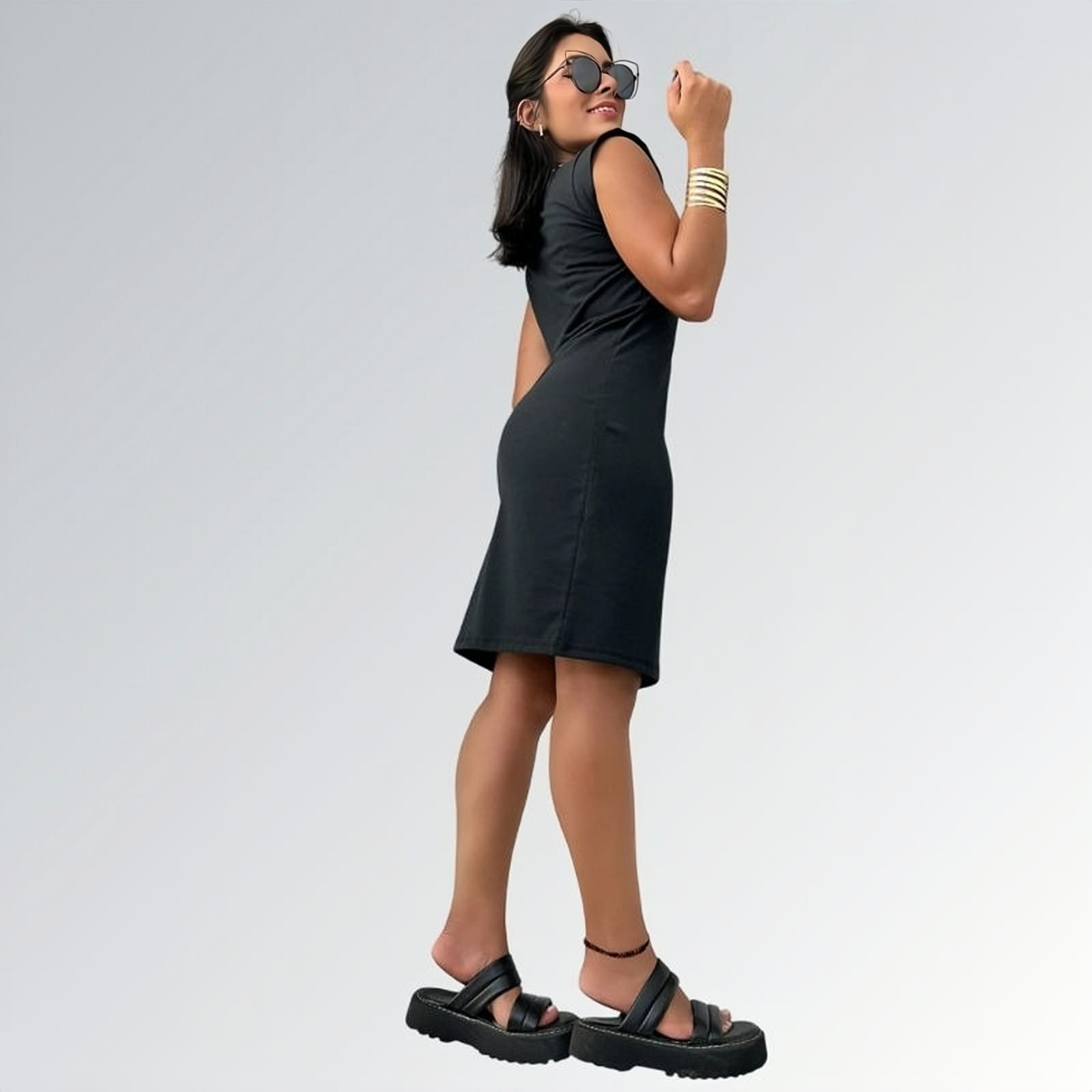 Vestido preto feminino curto de manga curta até o joelho com tecido liso, acessórios dourados e sandálias plataforma pretas — peça minimalista disponível para venda online de moda casual e semi-formal.