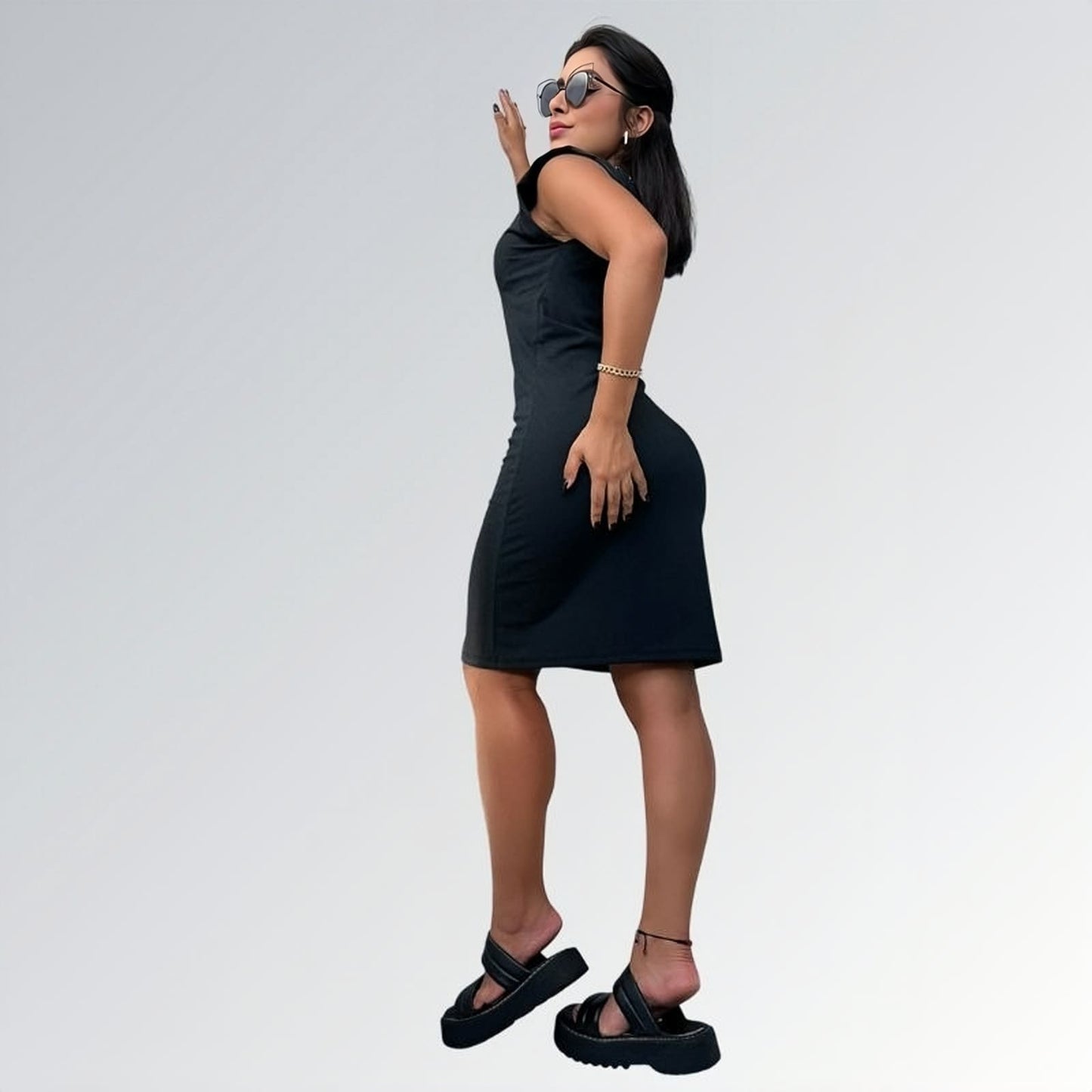 Vestido preto feminino curto de manga curta até o joelho com tecido liso, acessórios dourados e sandálias plataforma pretas — peça minimalista disponível para venda online de moda casual e semi-formal.